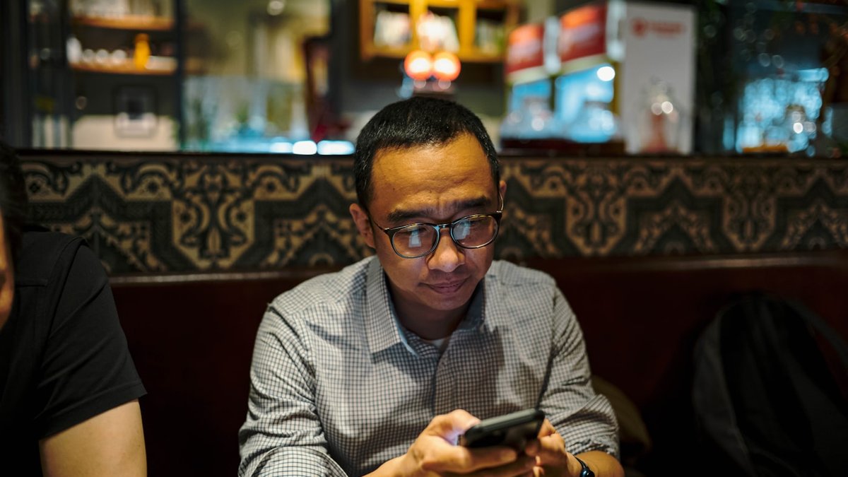 Un client attablé qui réserve sa table depuis son téléphone
