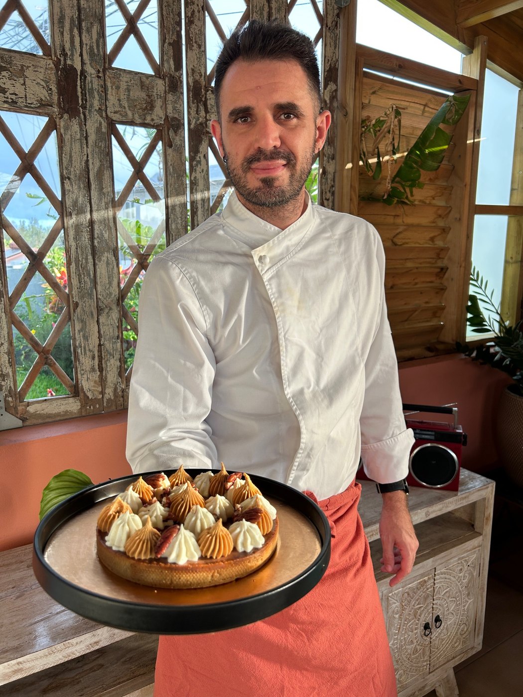 Pierre-Olivier Joseph en veste de cuisine, présentant une tarte